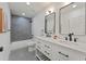Modern bathroom featuring double vanity with quartz countertop, black fixtures, and tiled shower at 1363 Diamond Se Ave, Atlanta, GA 30316