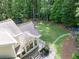 Aerial view of the backyard featuring a trampoline, fire pit with seating, stepping stone path, and large grassy area at 4673 Jefferson Township Pl, Marietta, GA 30066
