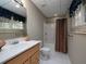 Bright bathroom features a single vanity, shower-tub combo with colorful curtain, tile floors, and window with blue valance at 4673 Jefferson Township Pl, Marietta, GA 30066