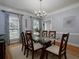 Elegant dining room with a glass-top table, hardwood floors, decorative accents, and natural light at 4673 Jefferson Township Pl, Marietta, GA 30066