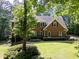 Traditional brick home with shutters, mature trees, landscaped yard, and a well-maintained lawn at 4673 Jefferson Township Pl, Marietta, GA 30066