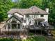 Attractive backyard featuring a large deck and sunroom surrounded by lush landscaping at 4673 Jefferson Township Pl, Marietta, GA 30066