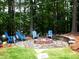 Cozy backyard fire pit area with Adirondack chairs, perfect for outdoor gatherings and relaxation in a wooded setting at 4673 Jefferson Township Pl, Marietta, GA 30066
