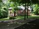 Charming brick home with manicured lawn and rock-lined garden beds, framed by mature trees and a long driveway at 4673 Jefferson Township Pl, Marietta, GA 30066