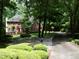 Attractive brick home with well-maintained landscaping, framed by mature trees along a winding driveway at 4673 Jefferson Township Pl, Marietta, GA 30066