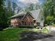Brick two-story home with dark shutters and a well-manicured lawn featuring lovely garden beds at 4673 Jefferson Township Pl, Marietta, GA 30066