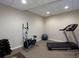 A home gym features a treadmill, elliptical, weights, and exercise ball on neutral carpeting, providing fitness at your doorstep at 4673 Jefferson Township Pl, Marietta, GA 30066