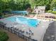 Community pool area with ample seating, lounge chairs, umbrellas, and a playground at 4673 Jefferson Township Pl, Marietta, GA 30066