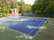 Community tennis courts with well-maintained blue courts surrounded by lush greenery and additional seating at 4673 Jefferson Township Pl, Marietta, GA 30066