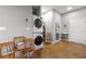 Bright laundry room with stacked washer and dryer, wooden shelving, and stylish decor elements at 5300 Peachtree Rd # 105, Atlanta, GA 30341