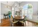 Light-filled dining room with hardwood floors, wainscoting, round wood table and chairs, plus large window at 931 Windsor Creek Dr, Grayson, GA 30017