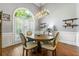 Dining room features hardwood floors, large window with plantation shutters, elegant light fixture and wainscoting at 931 Windsor Creek Dr, Grayson, GA 30017