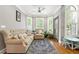 Cozy sitting room features hardwood floors, a tufted sofa and chair, plus bay windows with shutters at 931 Windsor Creek Dr, Grayson, GA 30017