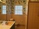 Retro bathroom featuring colorful tile, wallpaper, sink and toilet at 1053 Allgood Rd, Stone Mountain, GA 30083