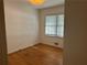 Clean bedroom with wood floors, white walls, and a window at 1053 Allgood Rd, Stone Mountain, GA 30083
