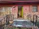 Close up of the entrance of the house featuring a green door, brick facade, and black metal handrails at 1053 Allgood Rd, Stone Mountain, GA 30083