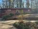 Exterior view of a brick home with a garage and a green door, surrounded by tall trees and natural landscaping at 1053 Allgood Rd, Stone Mountain, GA 30083