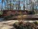 Exterior view of a brick home with a garage and a green door, surrounded by tall trees and natural landscaping at 1053 Allgood Rd, Stone Mountain, GA 30083
