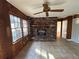Cozy living room featuring a brick fireplace, ceiling fan, and large windows at 1053 Allgood Rd, Stone Mountain, GA 30083