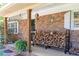 Close up of the front porch with brick columns and rustic wood stacked near the front door at 255 Shipp Cir, Hiram, GA 30141