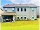 Back of house with well-manicured lawn, covered patio, and a row of windows allowing for lots of natural light at 2579 Wimberley Pine Ct, Dacula, GA 30019