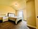 Bedroom featuring carpet floor, a bed with a headboard, a window, and a bedside table at 2579 Wimberley Pine Ct, Dacula, GA 30019