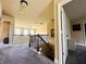 A naturally lit hallway featuring neutral colors, plush carpeting, and wrought iron banisters leading to the upper level at 2579 Wimberley Pine Ct, Dacula, GA 30019