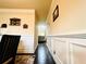 A hallway with an hardwood floor and wainscotting leads to a living room with sofa in this home at 2579 Wimberley Pine Ct, Dacula, GA 30019