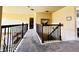 A naturally lit hallway with carpet and wrought iron banisters leading to the upper level at 2579 Wimberley Pine Ct, Dacula, GA 30019