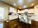 Charming kitchen with white cabinets, a center island, and dark wood floors and door to outside at 2579 Wimberley Pine Ct, Dacula, GA 30019