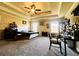 Carpeted main bedroom features tray ceiling, fan, windows, furniture, and view of outdoor trees at 2579 Wimberley Pine Ct, Dacula, GA 30019