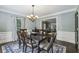 Traditional dining room features a dark wood table, blue accent rug, and contemporary chandelier at 3715 Borning Ct, Johns Creek, GA 30022