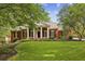 Charming brick home with a well-manicured lawn, lush landscaping, and classic colonial-style architecture at 3715 Borning Ct, Johns Creek, GA 30022