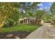Charming home with a beautifully landscaped front yard, showcasing lush greenery, mature trees, and a welcoming entrance at 3715 Borning Ct, Johns Creek, GA 30022
