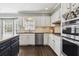 Updated kitchen with stainless steel appliances, white cabinets, and large bay windows at 3715 Borning Ct, Johns Creek, GA 30022
