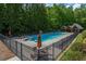 Community pool with lounge chairs, diving board, and sun umbrellas near lush greenery at 3715 Borning Ct, Johns Creek, GA 30022