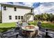 Relaxing backyard featuring a stone fire pit with chairs, a lush lawn, and wooded views at 129 Henley St, Canton, GA 30114