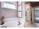 Bathroom with a large soaking tub and glass enclosed shower with marble surround at 129 Henley St, Canton, GA 30114