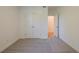 White bedroom with carpeted floors, double door closet, and open door to another room at 129 Henley St, Canton, GA 30114