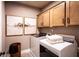 A clean and modern laundry room with a front-loading washer and dryer and light wood cabinets at 129 Henley St, Canton, GA 30114