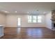 Open-concept living room with wood floors, ample windows, and a stone fireplace at 129 Henley St, Canton, GA 30114