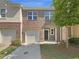 Brick townhome with two-car garage, inviting entrance and manicured lawn at 1958 Millstream Holw, Conyers, GA 30012