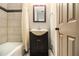 This bathroom features a single sink with black vanity, framed mirror, and tiled tub at 6590 Williamson Ne Dr, Atlanta, GA 30328