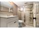 Bathroom with glass shower doors, white vanity, neutral tiling and modern fixtures at 6590 Williamson Ne Dr, Atlanta, GA 30328
