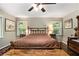 Bright bedroom with antique furniture, ceiling fan, and sunny windows overlooking the outdoor landscape at 6590 Williamson Ne Dr, Atlanta, GA 30328