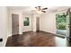 Bright bedroom featuring hardwood floors, a ceiling fan, and an open doorway to the outside at 6590 Williamson Ne Dr, Atlanta, GA 30328