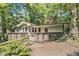 Exterior of the home featuring a wooden deck with decorative railings and lush natural surroundings at 6590 Williamson Ne Dr, Atlanta, GA 30328