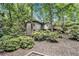 Exterior view of a gray two-story home nestled among the trees and surrounded by lush landscaping at 6590 Williamson Ne Dr, Atlanta, GA 30328