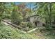 Exterior view of a gray home with mature landscaping and a stone pathway leading to the front door at 6590 Williamson Ne Dr, Atlanta, GA 30328