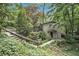 Charming home surrounded by lush greenery, featuring a stone pathway and inviting entrance, offering a serene setting at 6590 Williamson Ne Dr, Atlanta, GA 30328